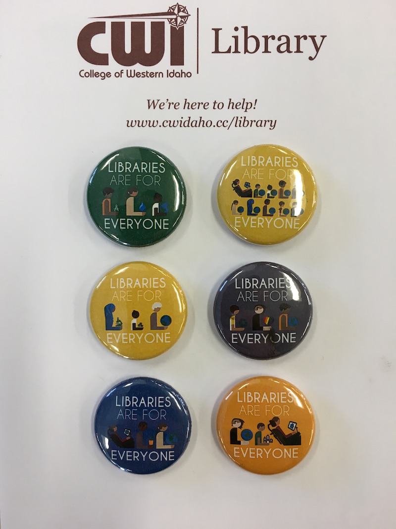 set of buttons that say Libraries are for Everyone, laying on CWI branded note paper